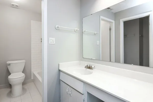 a bathroom with a sink toilet and a mirror