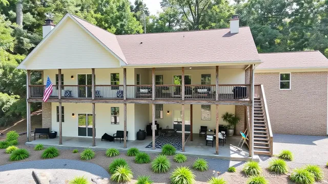 a living room with furniture and a dining table with potted plants