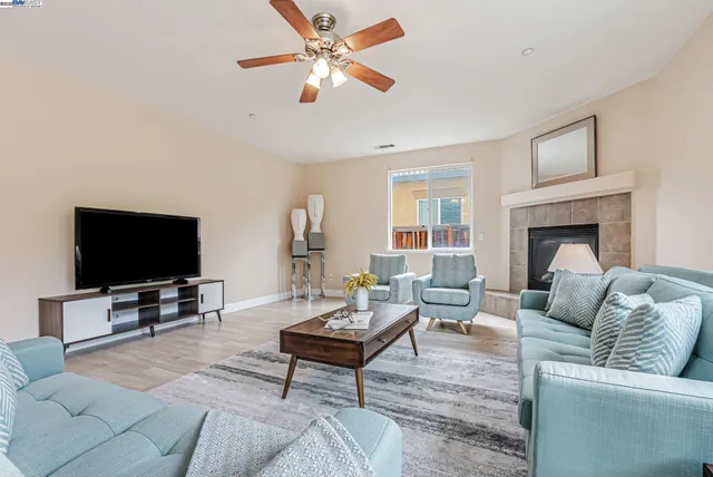 a living room with furniture a large window and a fireplace