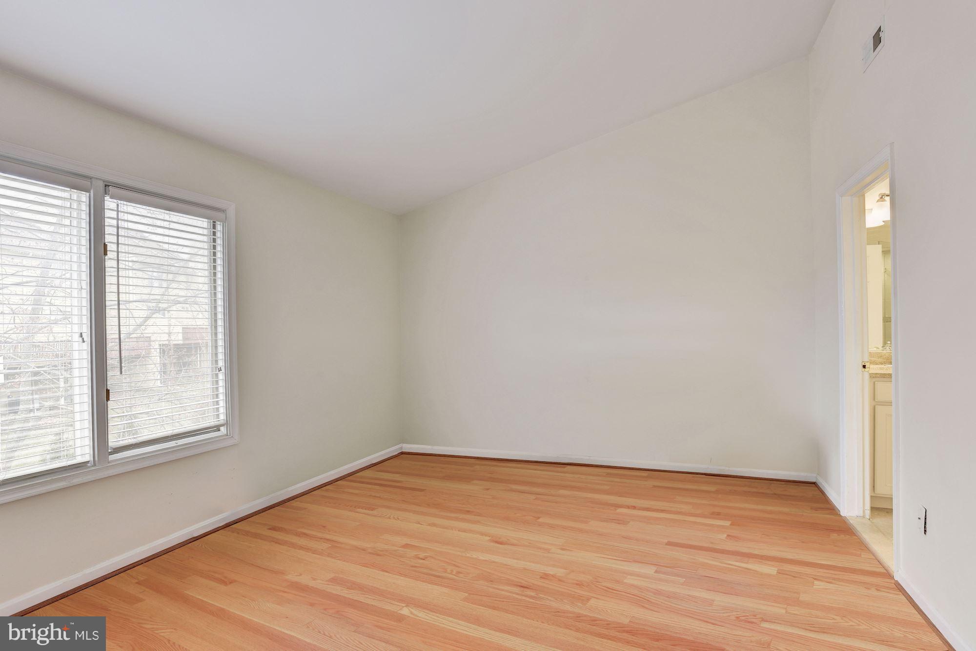 5133 Columbia Road, Unit 1595 Columbia, MD 21044 - Photo 13 of 30 wooden floor in an empty room with a window