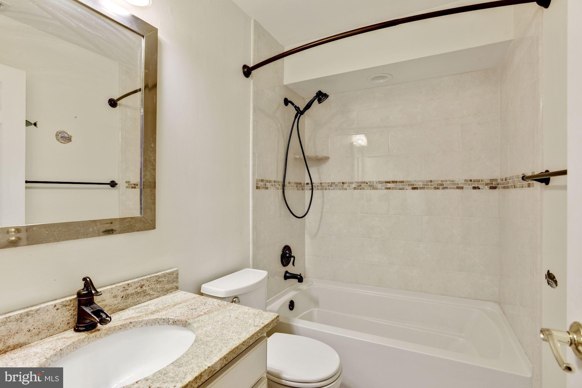 5133 Columbia Road, Unit 1595 Columbia, MD 21044 - Photo 20 of 30 a bathroom with a granite countertop sink mirror toilet and bathtub