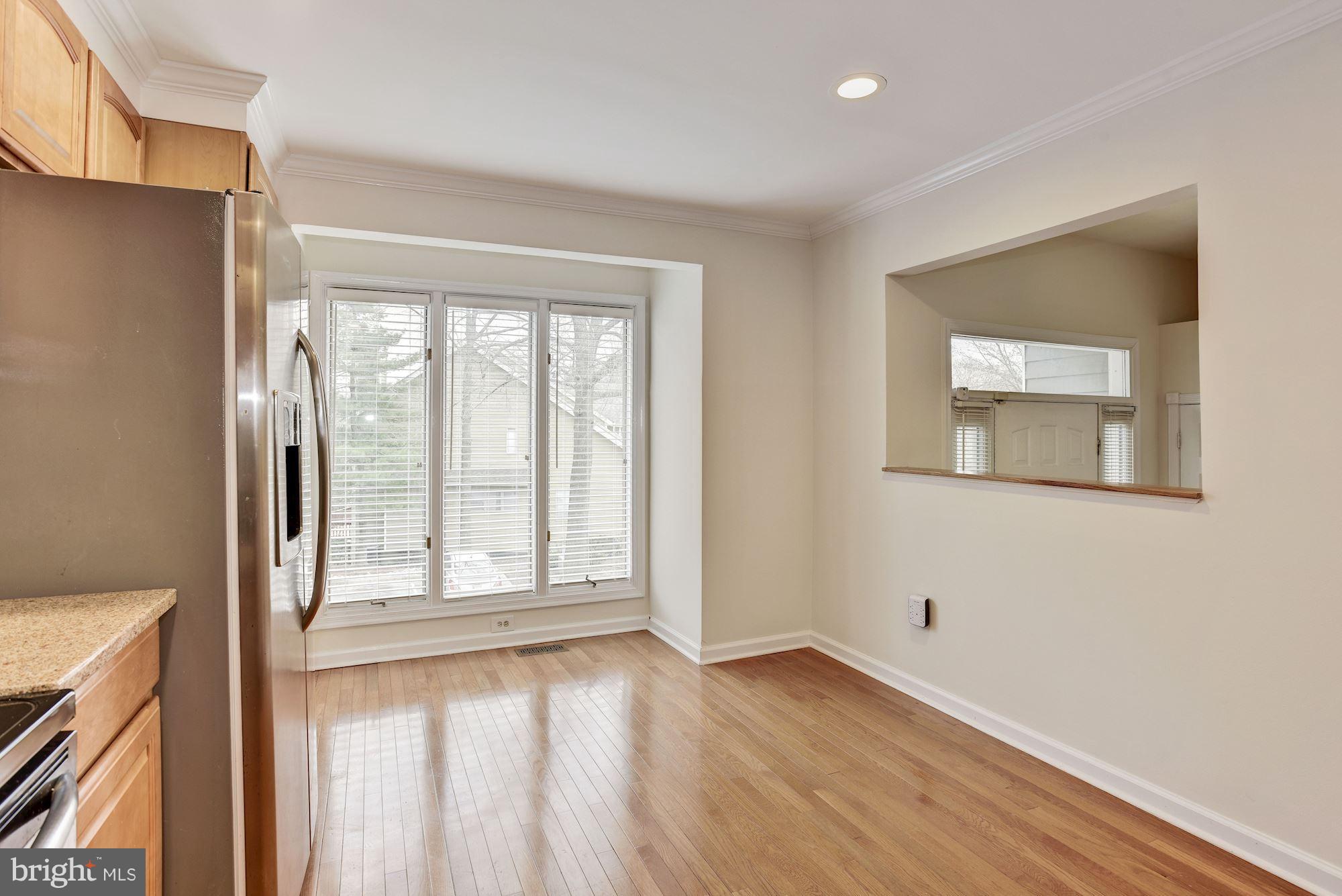 5133 Columbia Road, Unit 1595 Columbia, MD 21044 - Photo 5 of 30 a view of an empty room with wooden floor and a window