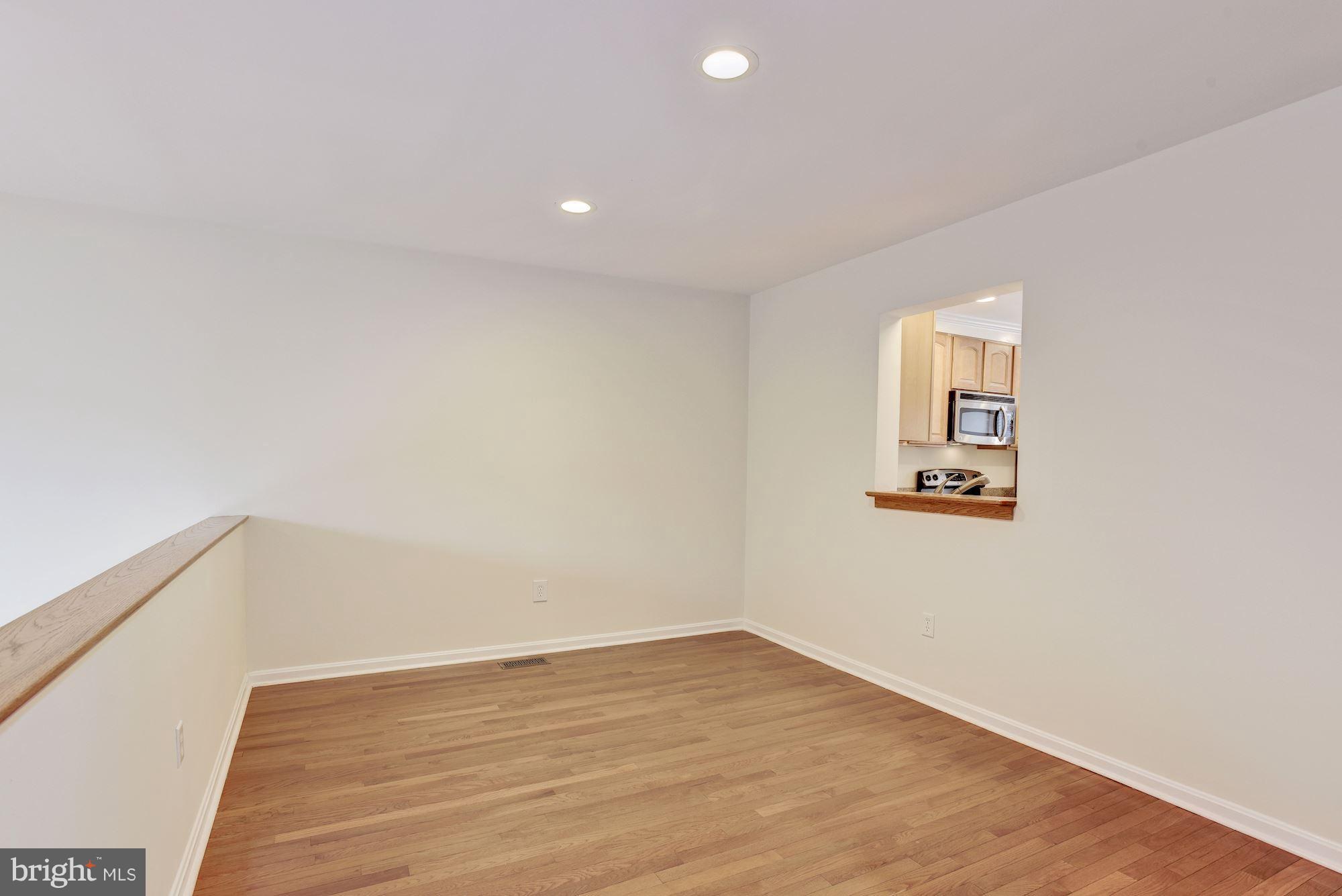 5133 Columbia Road, Unit 1595 Columbia, MD 21044 - Photo 6 of 30 a view of a room with wooden floor and white walls