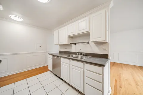 a kitchen with granite countertop white cabinets and white appliances