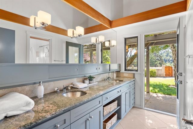 a bathroom with a granite countertop sink and a window