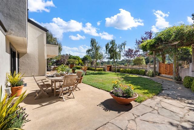 a view of a backyard with sitting area and garden