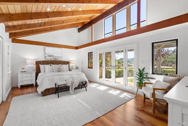 a spacious bedroom with a bed a table and chair