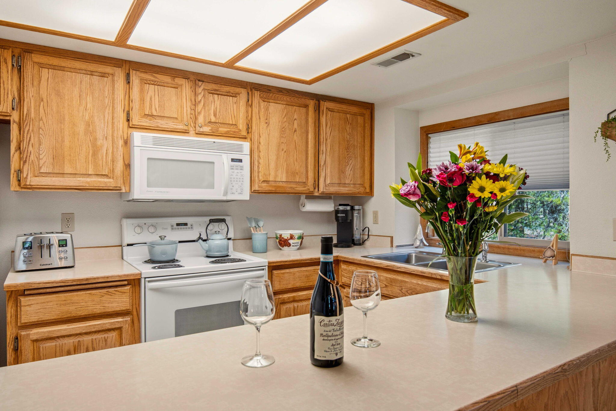 57305 Beaver Ridge Loop, Unit 8 Sunriver, OR 97707 - Photo 9 of 25 a kitchen with stainless steel appliances granite countertop a sink a stove and cabinets