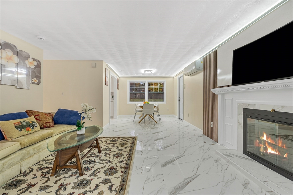 9 Donna Road Chelmsford, MA 01824 - Photo 3 of 37 a living room with furniture a flat screen tv and a fireplace