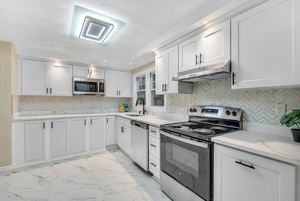 9 Donna Road Chelmsford, MA 01824 - Photo 9 of 37 a kitchen with cabinets appliances a sink and a counter top space