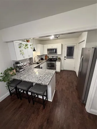 a living room with dining table and wooden floor