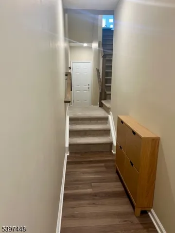 a view of a hallway with wooden floor and entryway