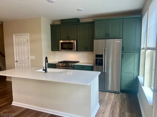 a kitchen with kitchen island a sink stainless steel appliances and cabinets
