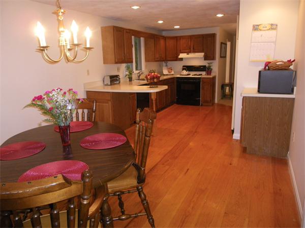 127 Patten Road Tewksbury, MA 01876 - Photo 3 of 16 a kitchen with stainless steel appliances kitchen island granite countertop a dining table chairs sink and white cabinets