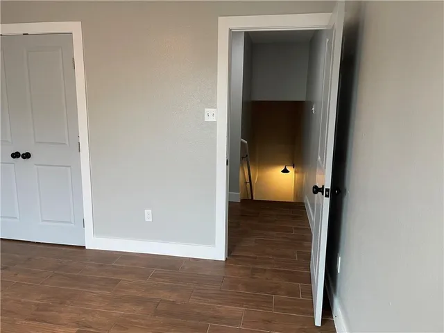 a view of a hallway with wooden floor and closet