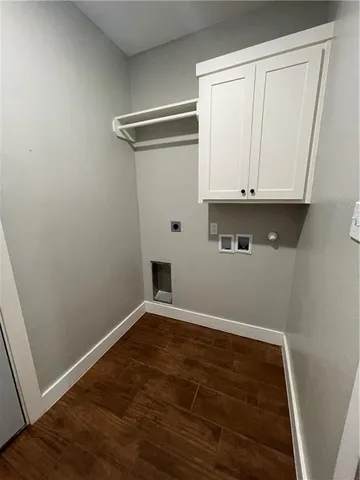 a view of an empty room with wooden floor and closet