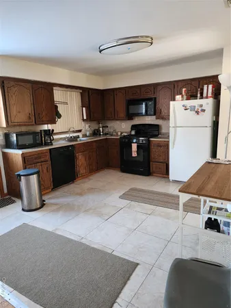 a kitchen with stainless steel appliances kitchen island granite countertop a sink dishwasher stove top oven and refrigerator