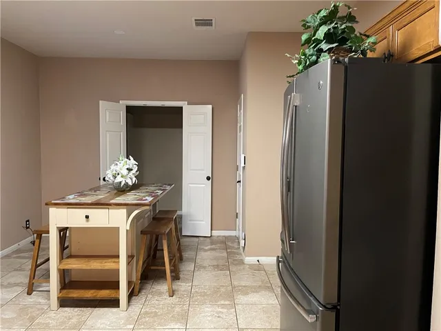 a dining room filled with furniture and a potted plant