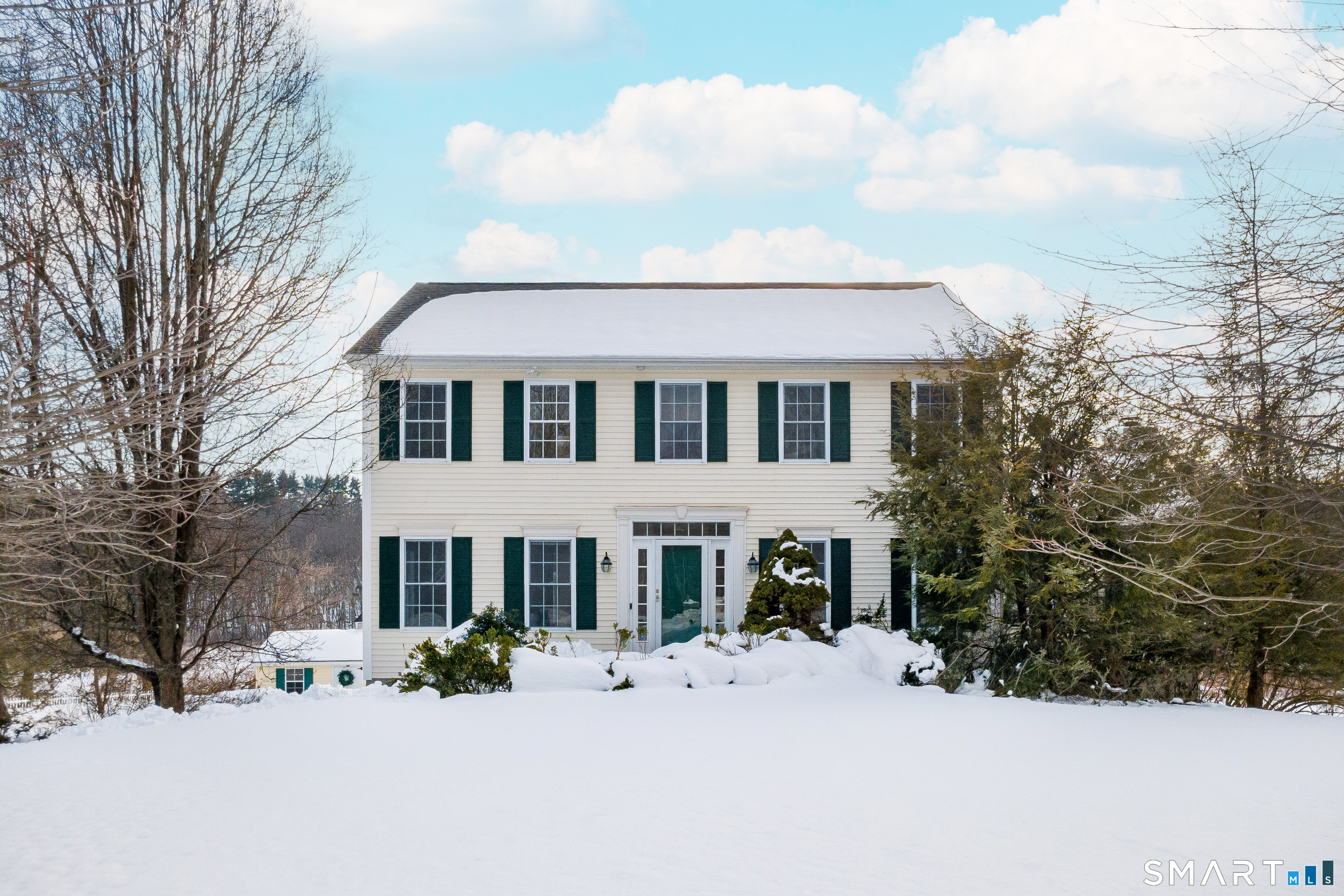 Front entry with charming green door and symmetrical windows.