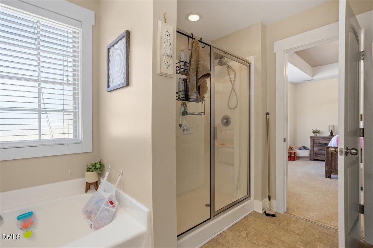 4222 Vineyard Ridge Drive Zebulon, NC 27597 - Photo 17 of 39 a bathroom with a tub a sink and a window