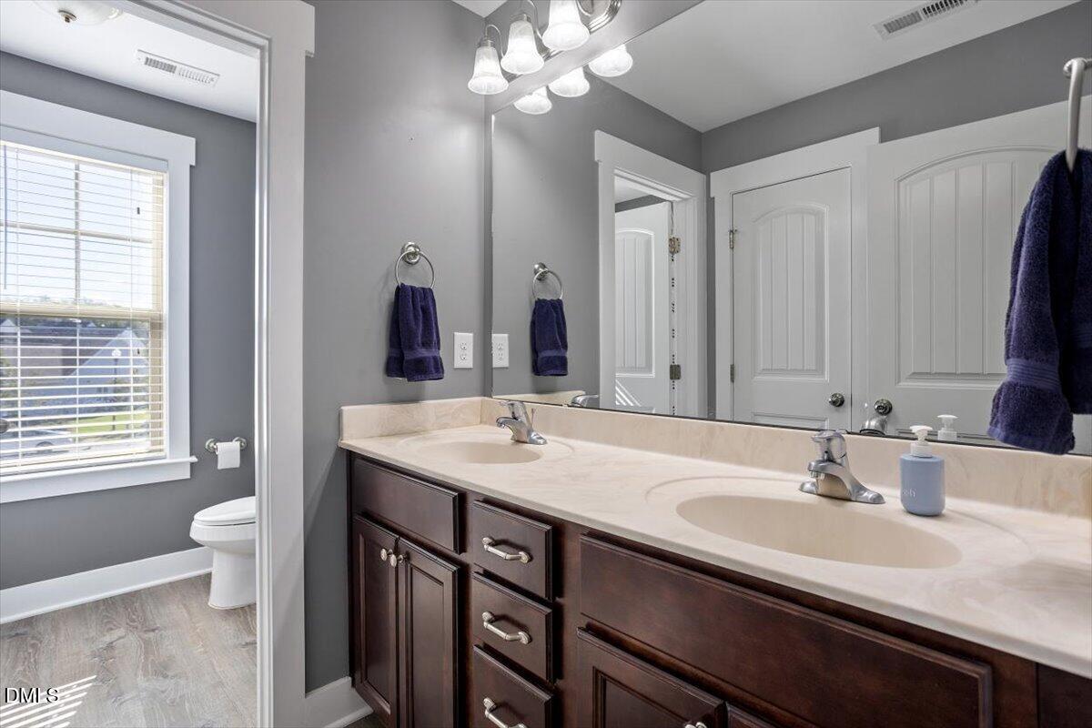 4222 Vineyard Ridge Drive Zebulon, NC 27597 - Photo 18 of 39 a bathroom with a granite countertop sink a large mirror and a toilet