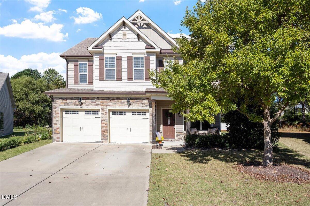 4222 Vineyard Ridge Drive Zebulon, NC 27597 - Photo 2 of 39 a view of a white house with a large tree