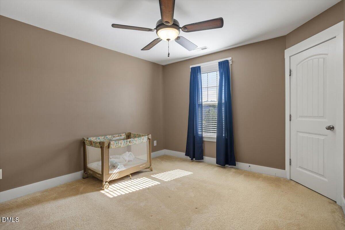 4222 Vineyard Ridge Drive Zebulon, NC 27597 - Photo 21 of 39 an empty room with windows and fan