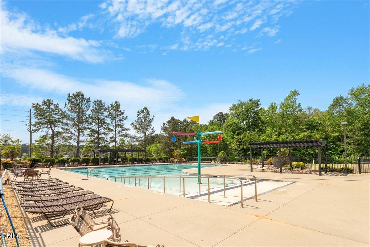 4222 Vineyard Ridge Drive Zebulon, NC 27597 - Photo 39 of 39 a view of swimming pool with seating area and trees in the background
