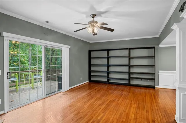 a view of an empty room with a window and wooden floor