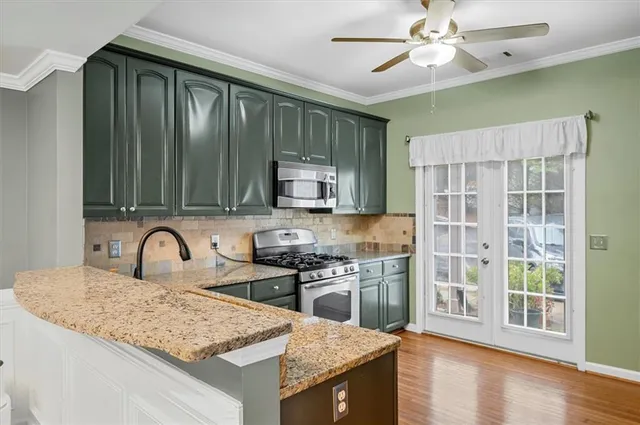 a kitchen with granite countertop a stove a sink and a wooden cabinets
