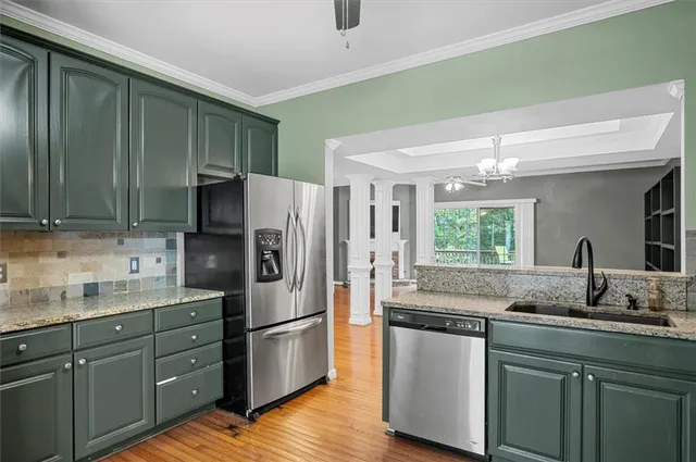 a kitchen with stainless steel appliances granite countertop a sink and a refrigerator