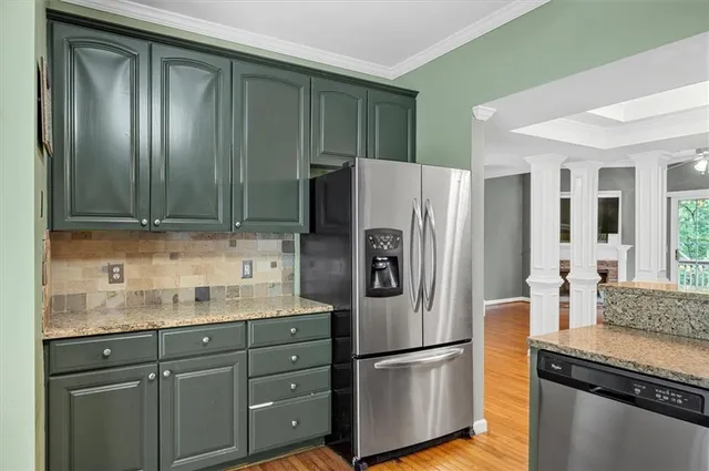 a kitchen with granite countertop stainless steel appliances and refrigerator