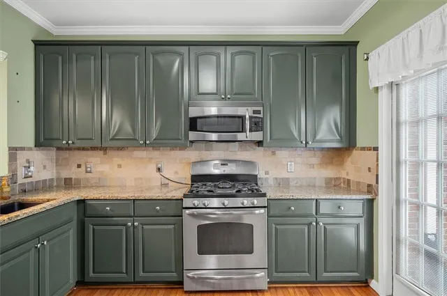 a kitchen with granite countertop cabinets stainless steel appliances and a sink