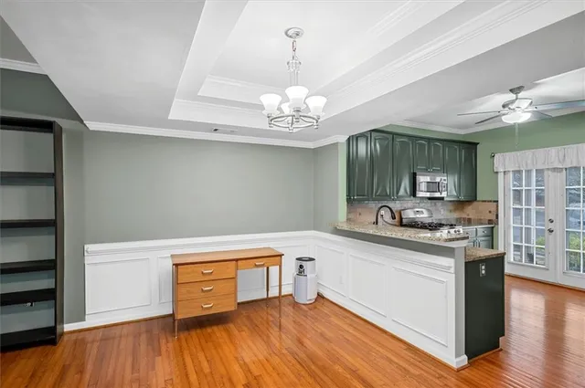 a kitchen with a stove and wooden floor