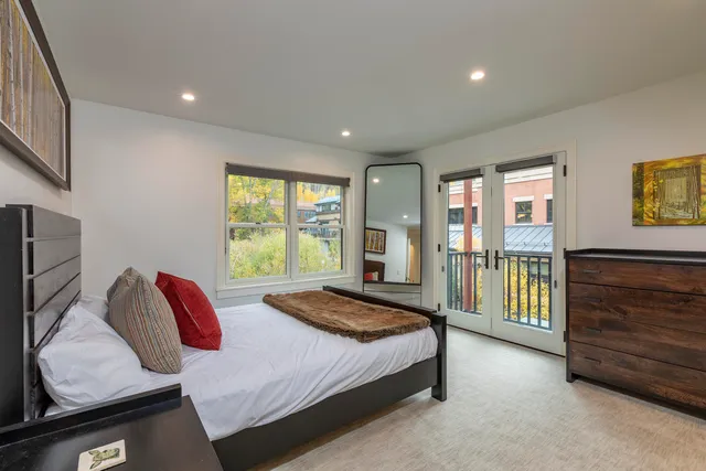 a bedroom with a bed and large window