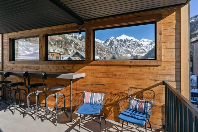 a view of a patio with table and chairs with wooden floor and fence