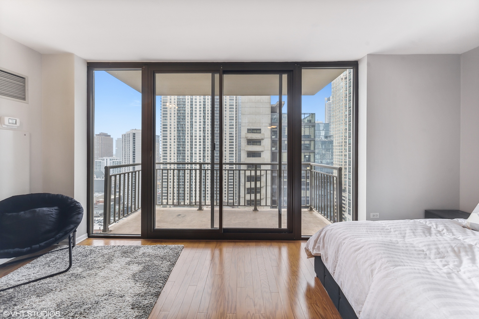 630 North State Street, Unit 2401 Chicago, IL 60654 - Photo 3 of 14 a view of a bedroom with a balcony and large bed
