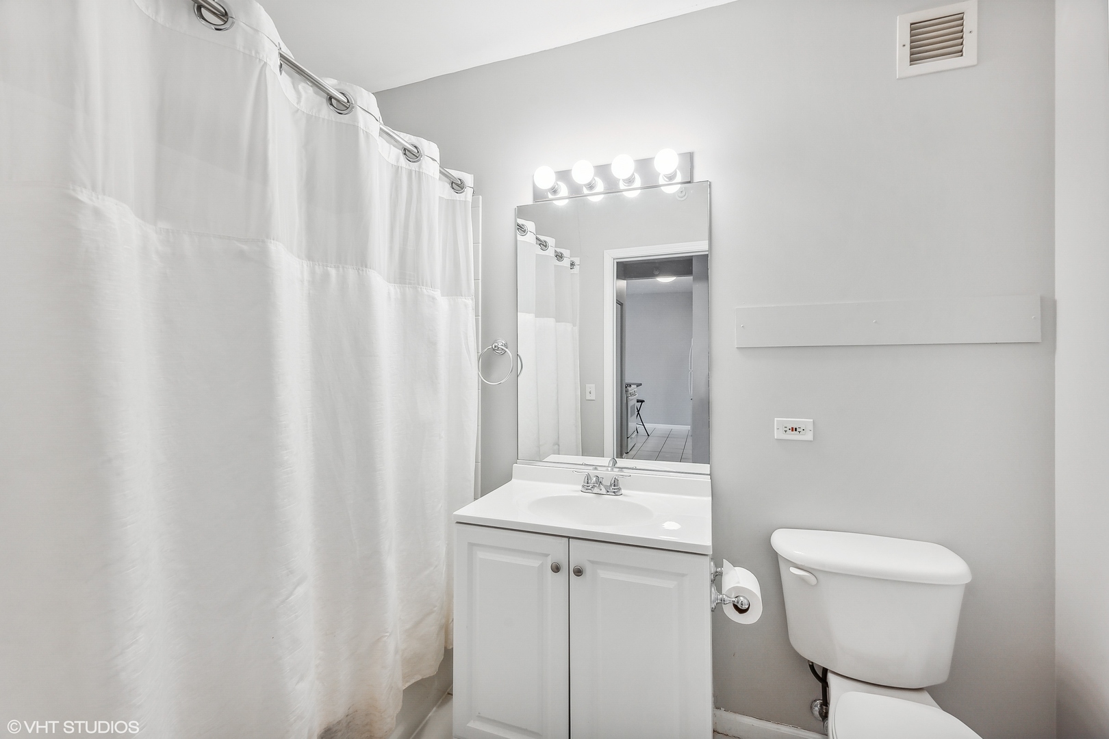 630 North State Street, Unit 2401 Chicago, IL 60654 - Photo 9 of 14 a bathroom with a toilet a sink and a mirror