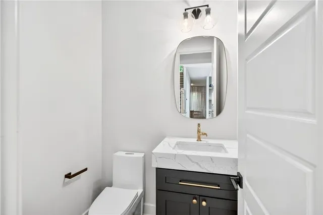 a bathroom with a toilet a sink and mirror