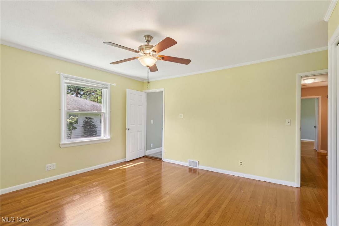 5097 Chillicothe Road Chagrin Falls, OH 44022 - Photo 25 of 45 Empty room with hardwood / wood-style floors, a ceiling fan, and crown molding