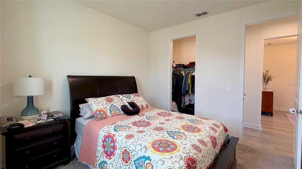 727 Annabell Rdg Road Minneola, FL 34715 - Photo 13 of 56 a bedroom with a bed and a lamp