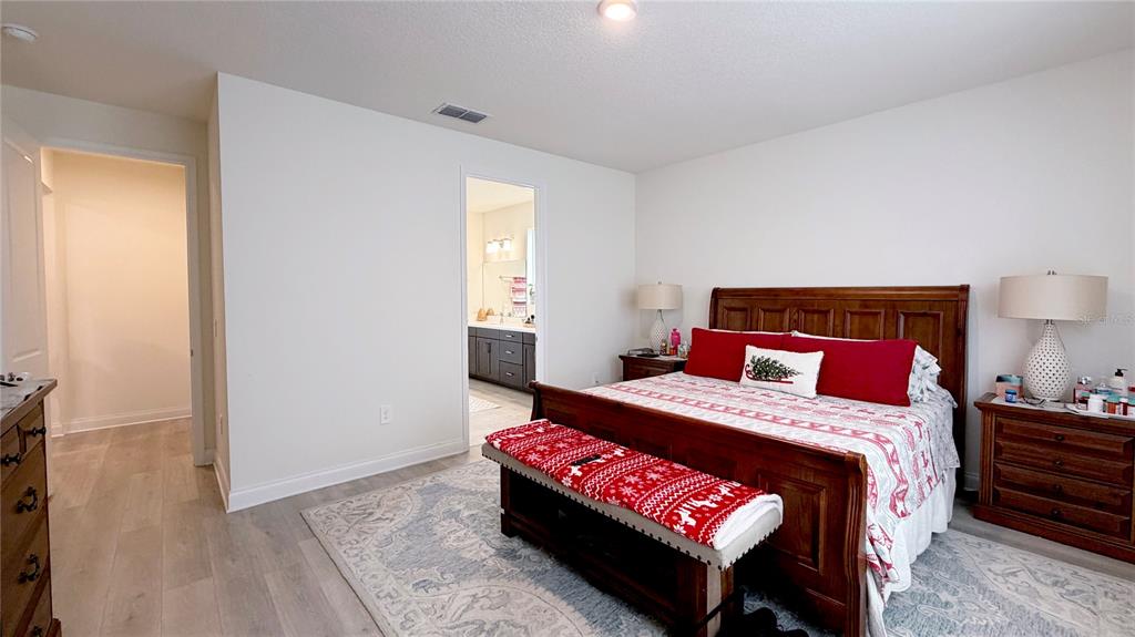 727 Annabell Rdg Road Minneola, FL 34715 - Photo 34 of 56 a bedroom with a bed and a lamp on table