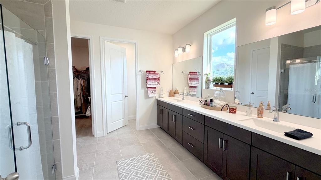 727 Annabell Rdg Road Minneola, FL 34715 - Photo 36 of 56 a large bathroom with a double vanity sink a large mirror and a bathtub