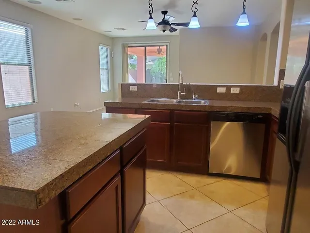 a kitchen with stainless steel appliances granite countertop a refrigerator and a stove