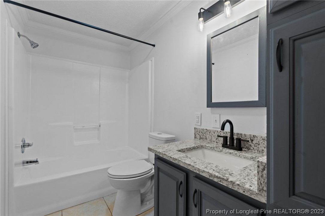 287 Doyle Cox Road Sanford, NC 27330 - Photo 16 of 35 a bathroom with a granite countertop sink toilet and shower
