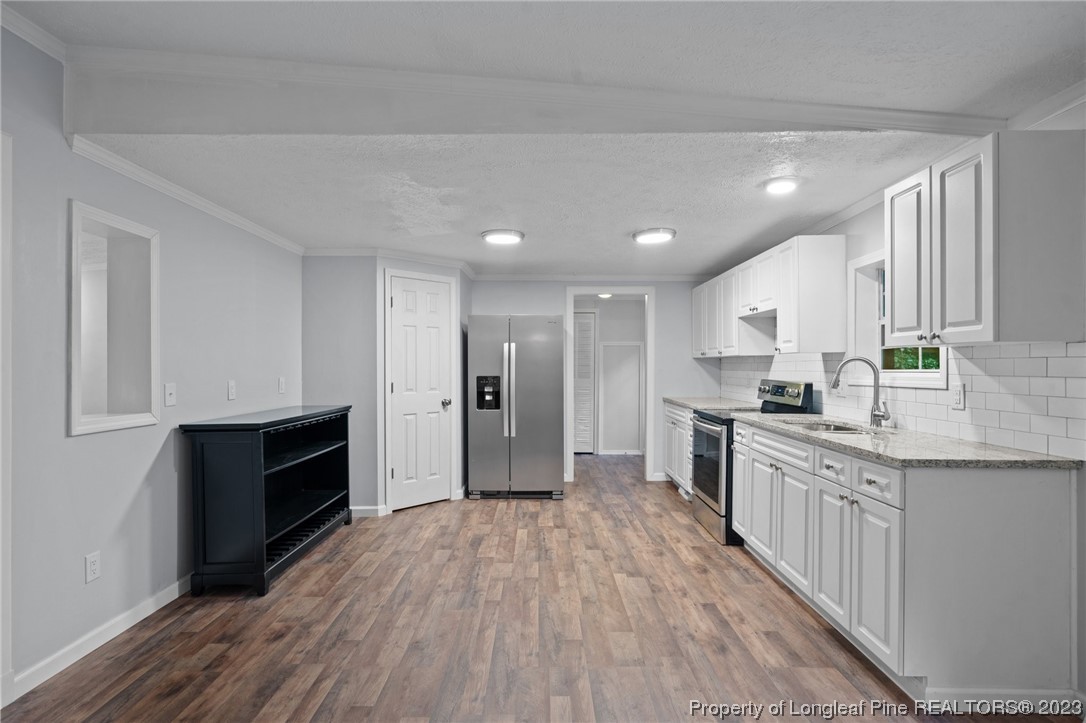 287 Doyle Cox Road Sanford, NC 27330 - Photo 19 of 35 a large kitchen with a center island wooden floor stainless steel appliances and cabinets