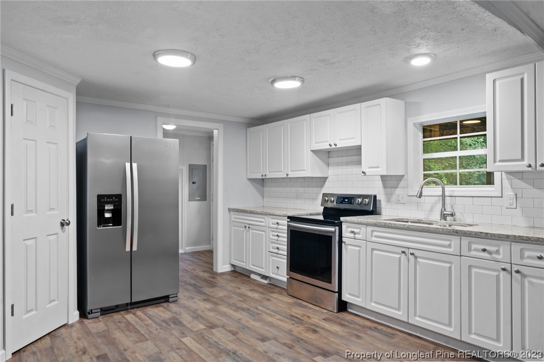 287 Doyle Cox Road Sanford, NC 27330 - Photo 20 of 35 a kitchen with stainless steel appliances granite countertop a stove a refrigerator and a sink