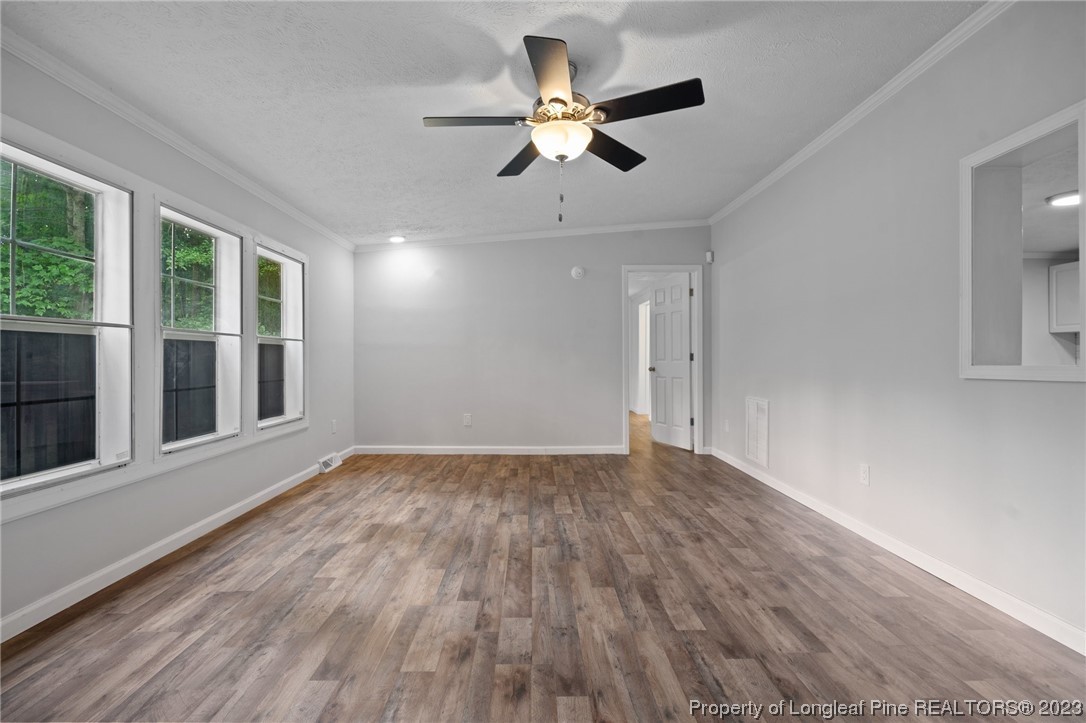 287 Doyle Cox Road Sanford, NC 27330 - Photo 2 of 35 a view of an empty room with window and wooden floor