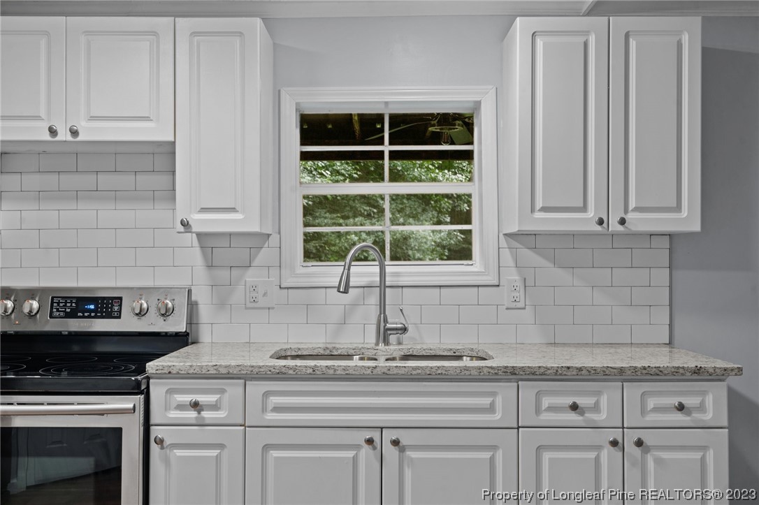 287 Doyle Cox Road Sanford, NC 27330 - Photo 23 of 35 a kitchen with white cabinets and a stove top oven