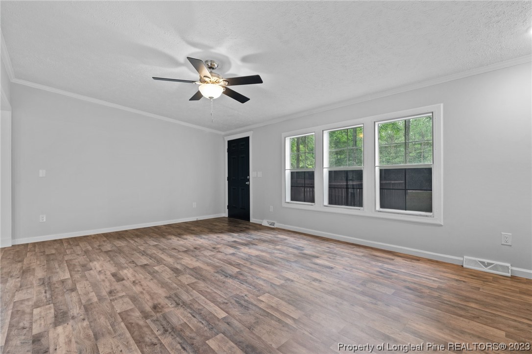 287 Doyle Cox Road Sanford, NC 27330 - Photo 5 of 35 a view of an empty room with a window and wooden floor